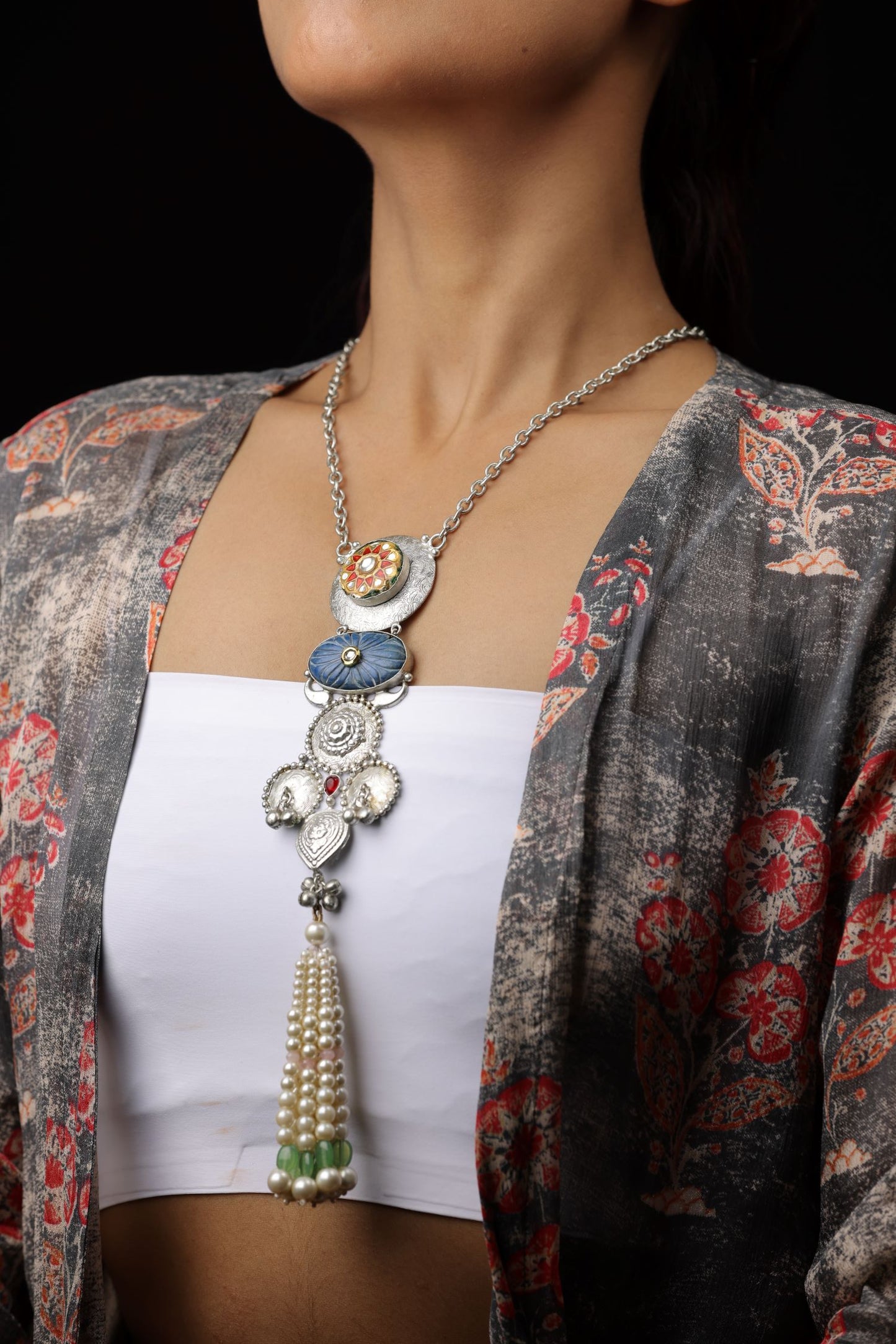 A long, silver-toned chain with a multi-element pendant.