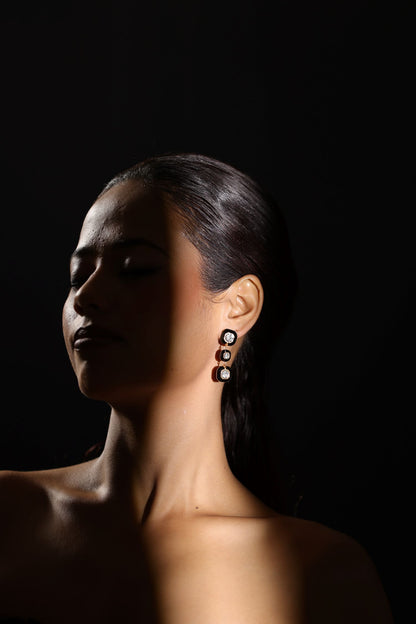 Dangling design earring with three bezel set square shaped gemstones